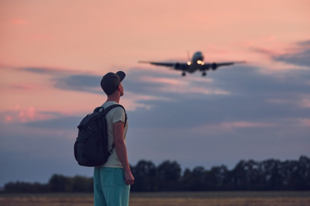 man looking up at flying airplane 2021 08 30 16 35 45 utc 1024x683 - City break zamiast Blue Monday - sprawdź, gdzie warto się wybrać